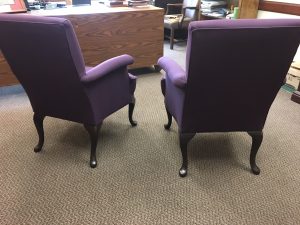 Rear view of two purple upholstered chairs.
