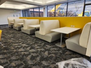 A row of upholstered benches next to a wall.