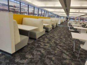 A row of white upholstered benches from an angle that shows them in a large room.