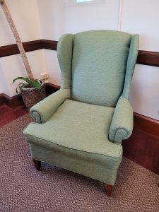 An angled view of a green upholstered chair.
